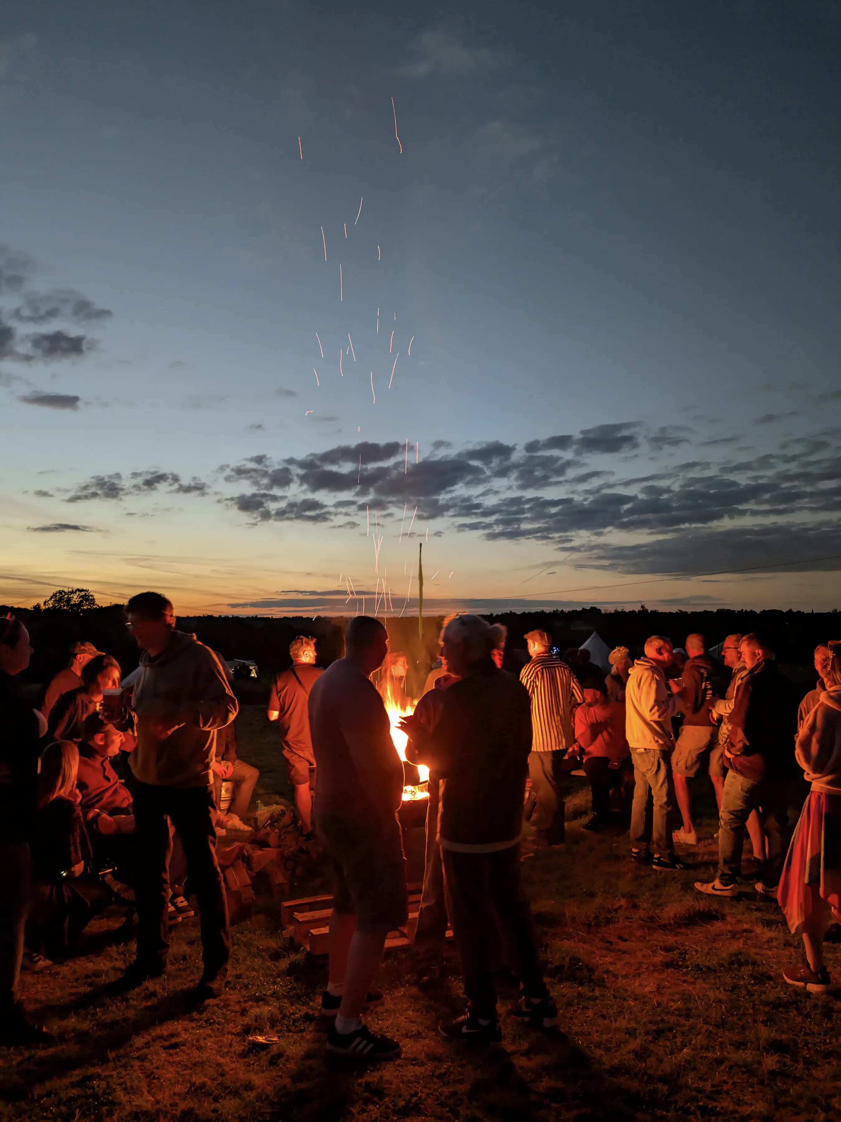 People gathered around a firepit at night