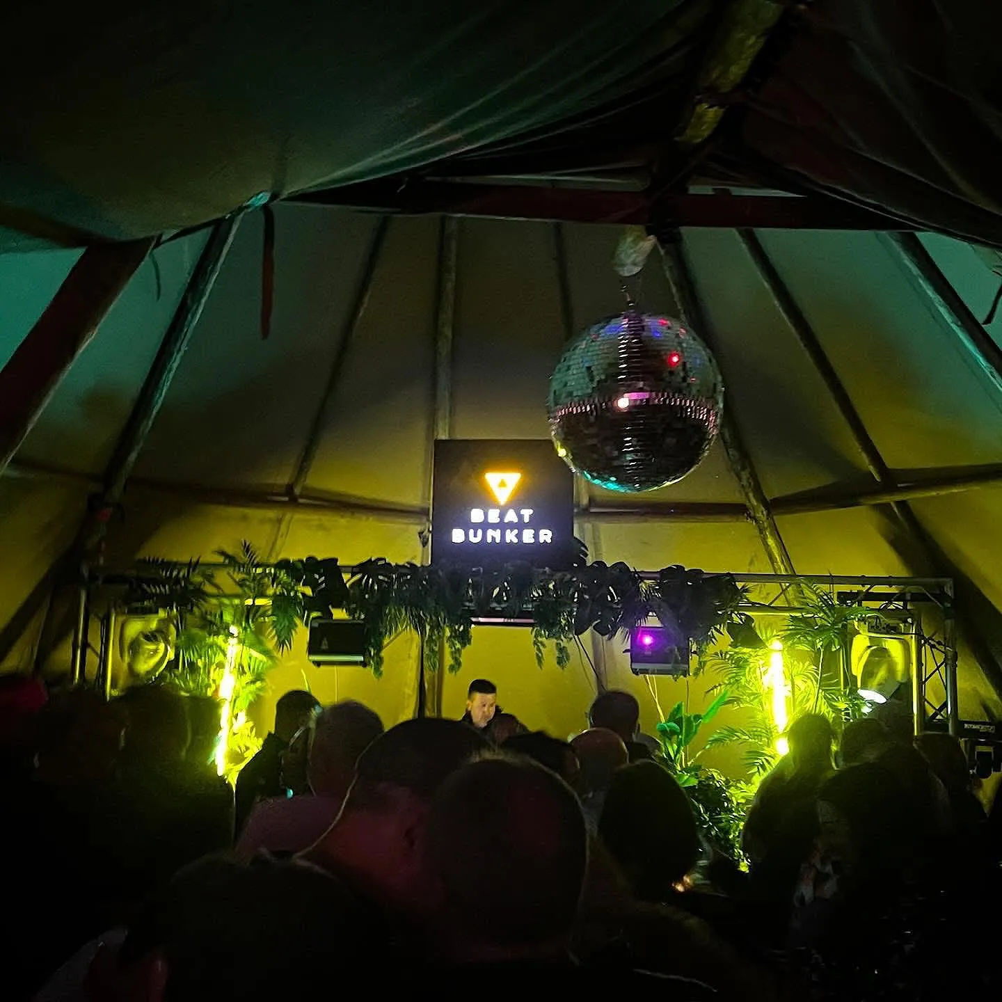 The Beat Bunker party tent lit up at night on the festival field